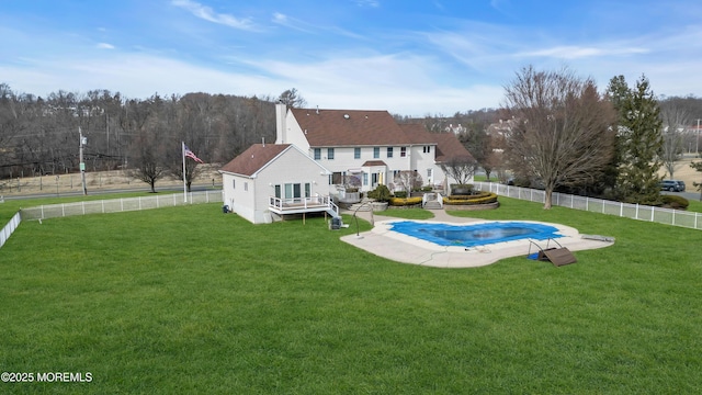 view of swimming pool with a fenced backyard, a lawn, a fenced in pool, and a wooden deck