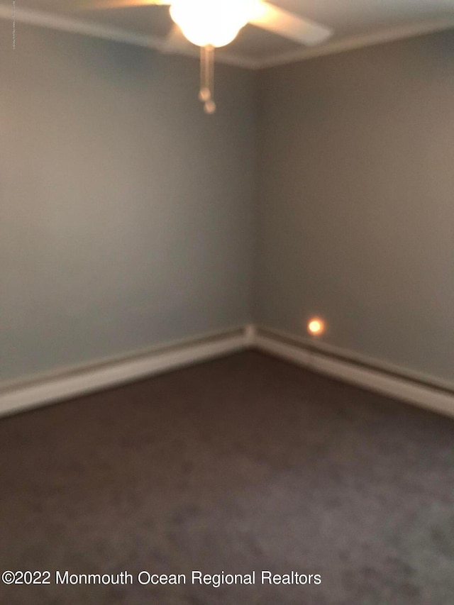 carpeted empty room featuring baseboard heating and ceiling fan