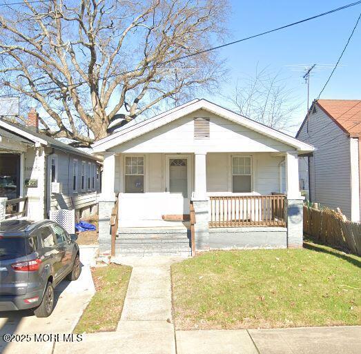 bungalow with a front lawn and a porch