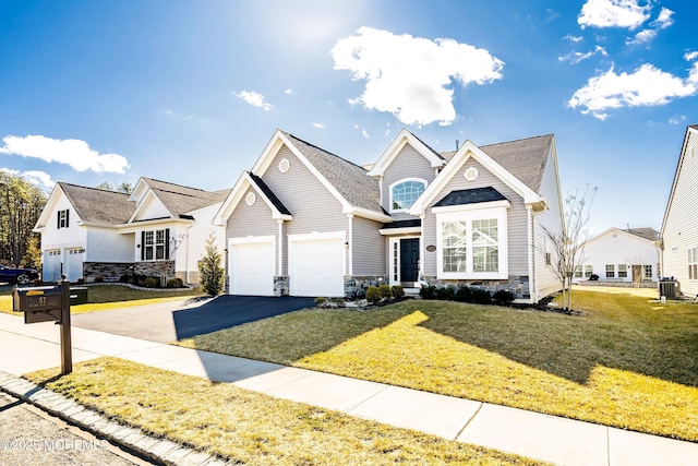 view of front of home with a garage, central AC, and a front yard