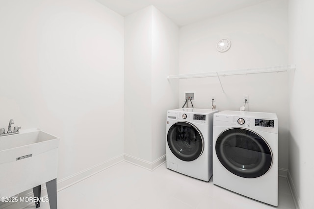 clothes washing area featuring washing machine and dryer and sink