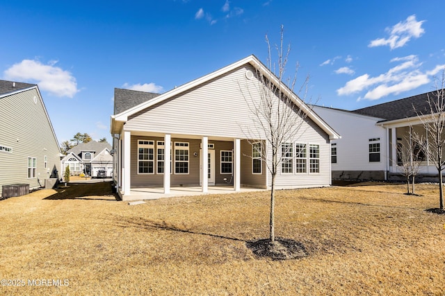 rear view of property featuring a yard, central air condition unit, and a patio area