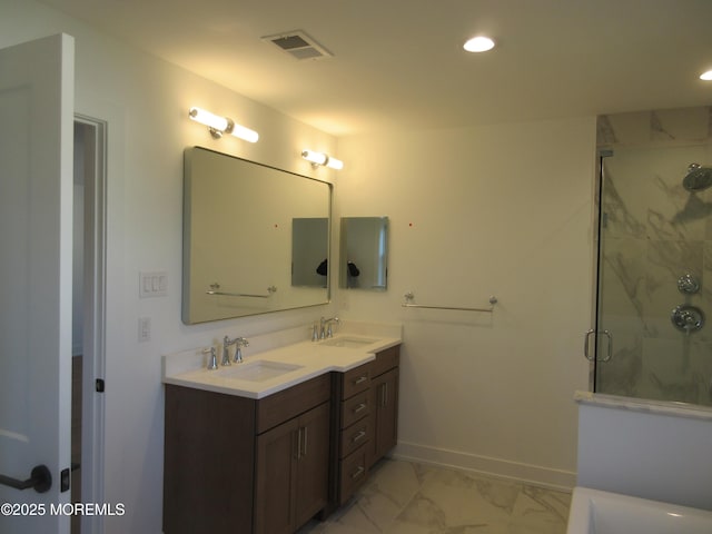 bathroom featuring a shower with door and vanity