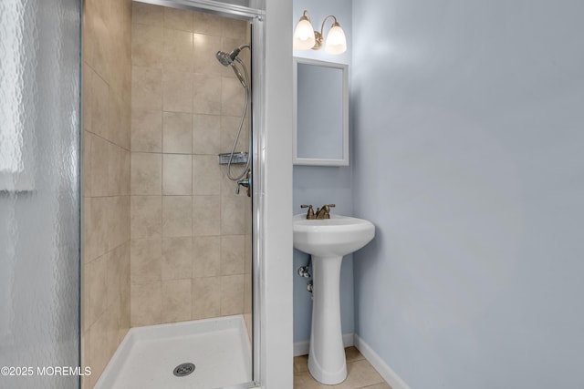 full bathroom featuring a shower stall, baseboards, and tile patterned floors