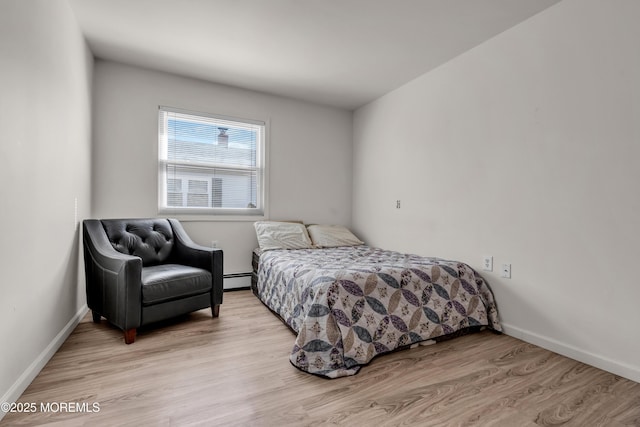 bedroom featuring light wood-type flooring, baseboards, and a baseboard radiator