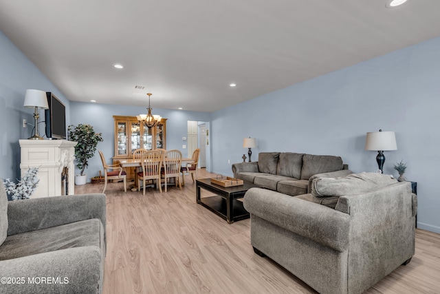 living area with a chandelier, light wood-type flooring, baseboards, and recessed lighting