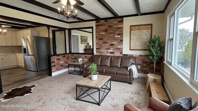 living area featuring beamed ceiling, carpet floors, a textured ceiling, and brick wall