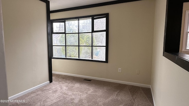 spare room featuring visible vents, carpet floors, and baseboards