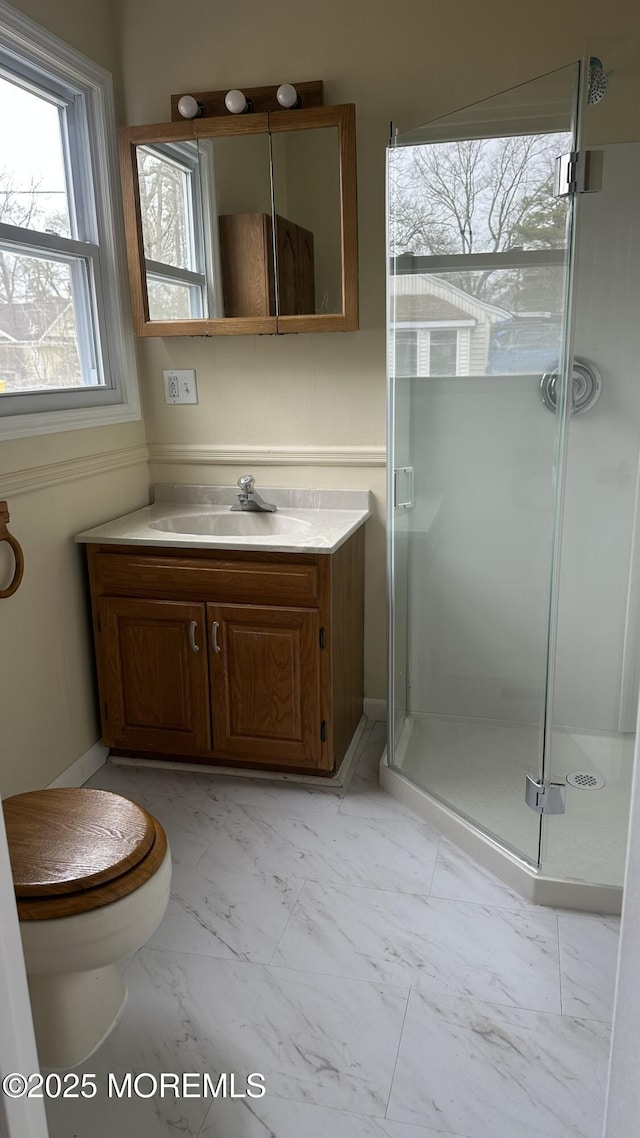 full bathroom with vanity, toilet, marble finish floor, and a stall shower