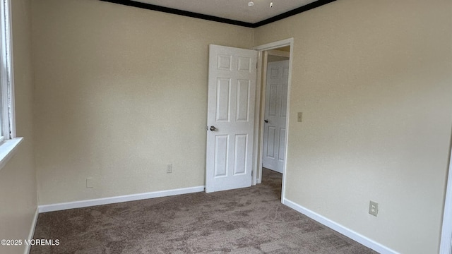 carpeted empty room with baseboards and ornamental molding