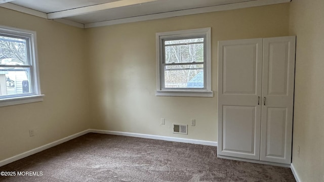 empty room with visible vents, carpet flooring, and baseboards