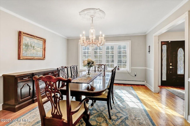 dining room with baseboard heating, crown molding, a chandelier, and light hardwood / wood-style flooring