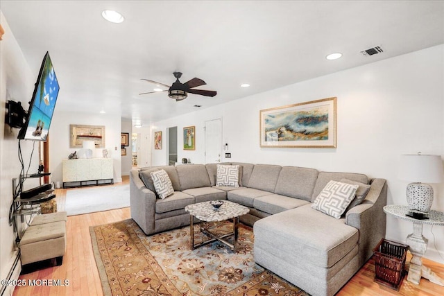 living room with hardwood / wood-style flooring and ceiling fan