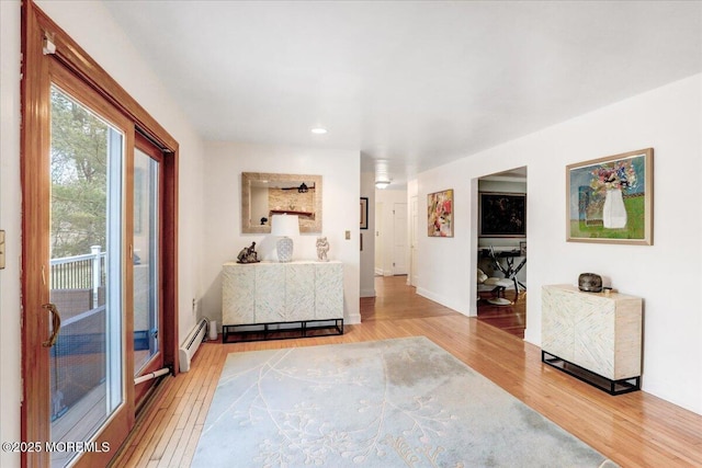 interior space with hardwood / wood-style floors and baseboard heating