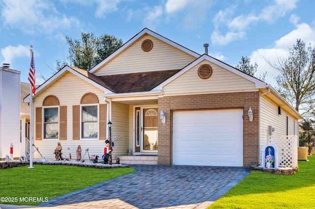 view of front facade with decorative driveway, brick siding, a shingled roof, a front yard, and a garage