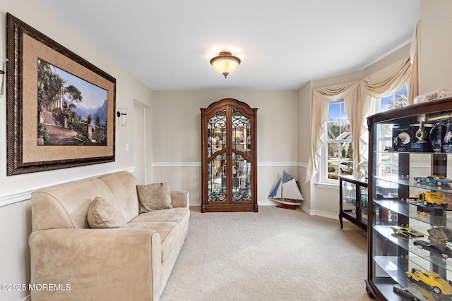 living area featuring light carpet and baseboards