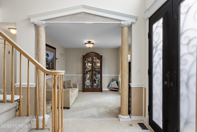 foyer entrance with decorative columns, stairway, and french doors