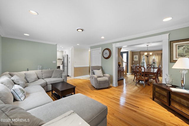 living room with crown molding, recessed lighting, a chandelier, and light wood-style floors