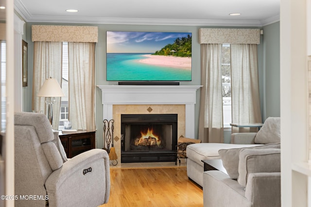 living area with recessed lighting, light wood-type flooring, a fireplace, and crown molding