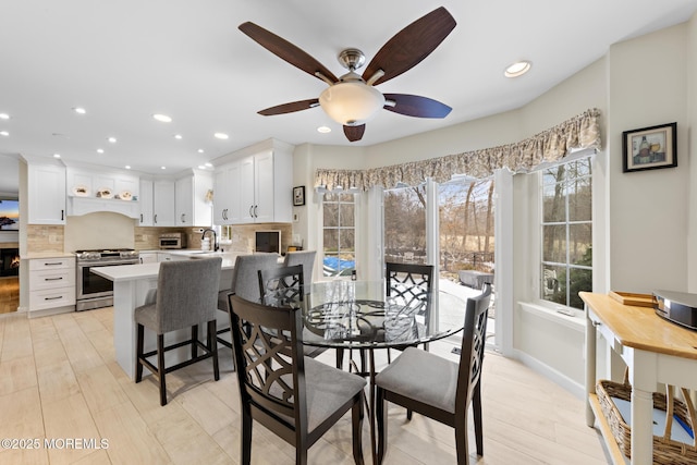 dining room with a toaster, ceiling fan, baseboards, and recessed lighting