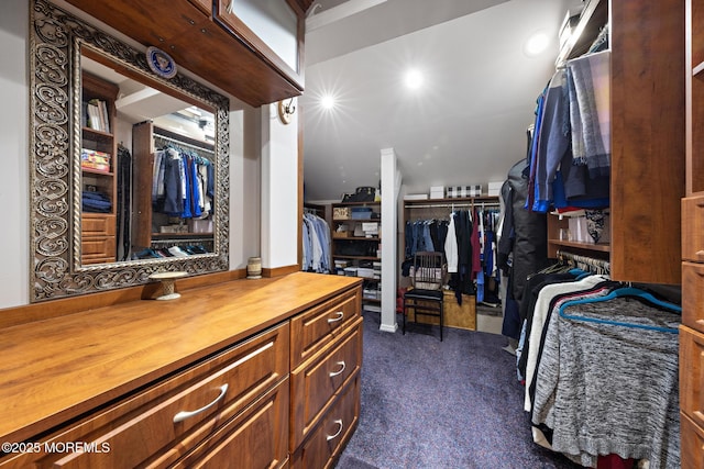 walk in closet with dark carpet