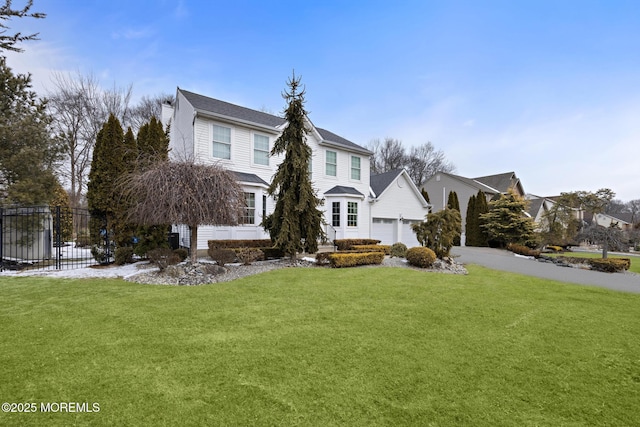 view of front of house with an attached garage, fence, driveway, a residential view, and a front yard