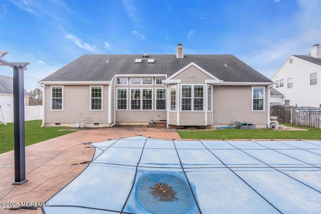 rear view of property featuring a patio, a yard, and a covered pool