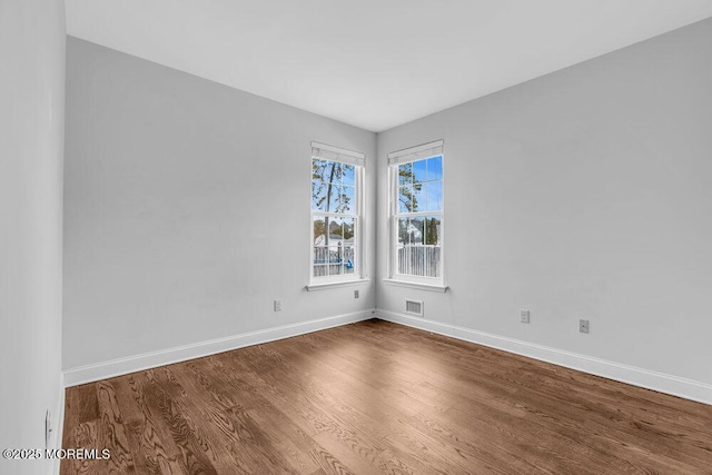 empty room with hardwood / wood-style flooring