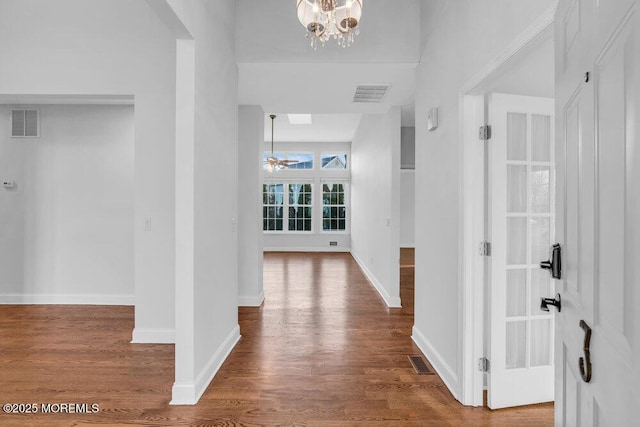 hallway with a notable chandelier and wood-type flooring