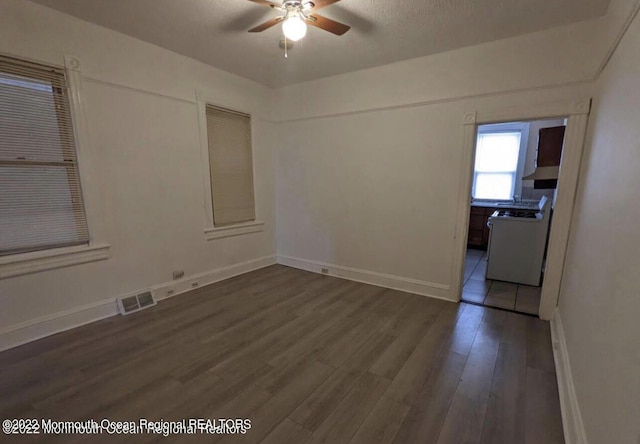 spare room featuring dark hardwood / wood-style flooring and ceiling fan