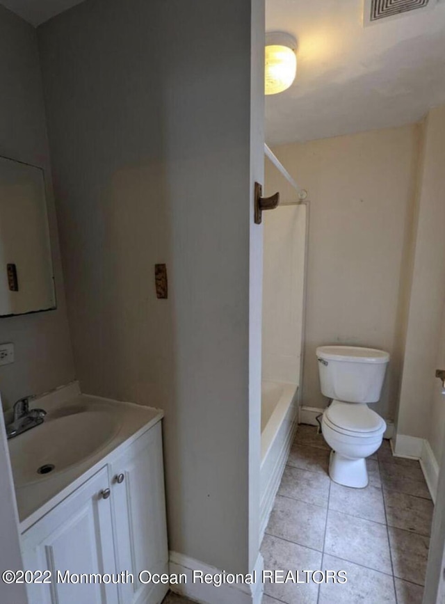 bathroom featuring toilet, vanity, and tile patterned flooring