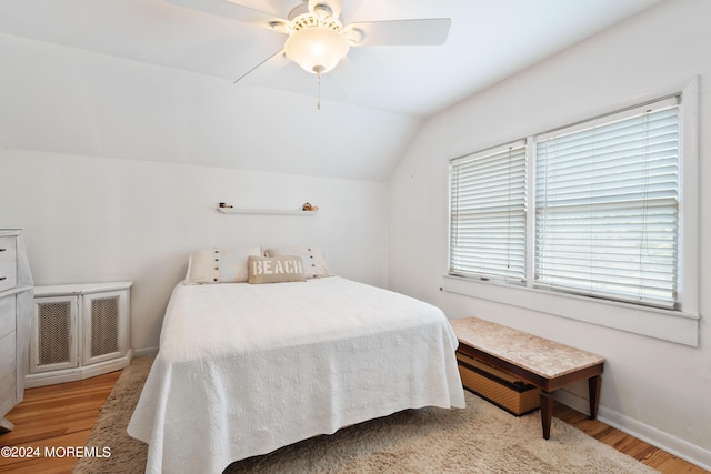 bedroom featuring lofted ceiling, light wood-type flooring, baseboards, and ceiling fan