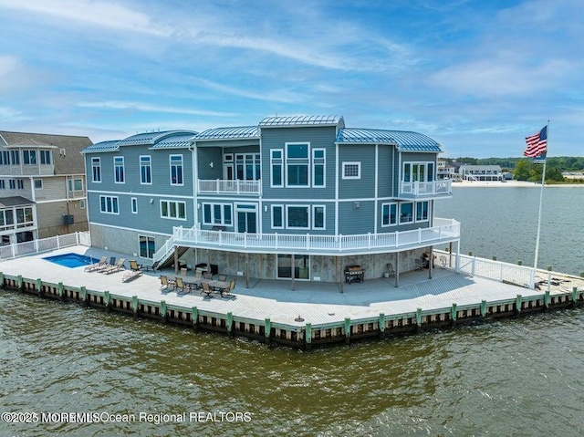 back of house with a patio, a deck with water view, and a balcony