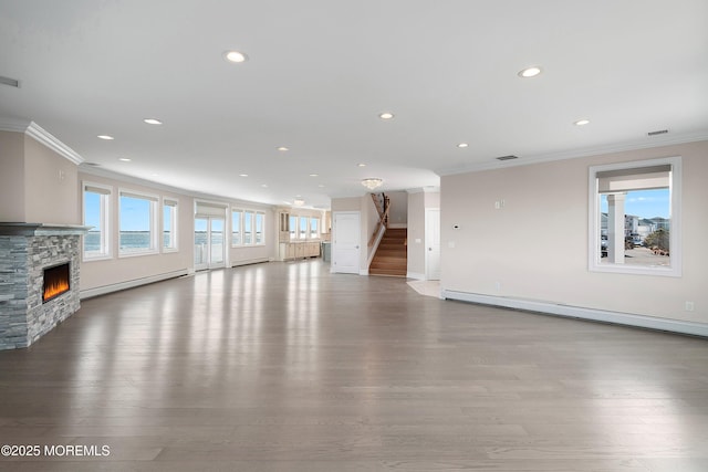 unfurnished living room with a baseboard radiator, ornamental molding, hardwood / wood-style floors, and a fireplace