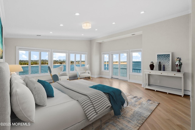 bedroom featuring multiple windows, a water view, crown molding, and access to exterior