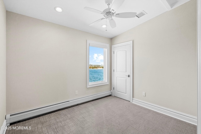 spare room with light carpet, ceiling fan, and a baseboard heating unit