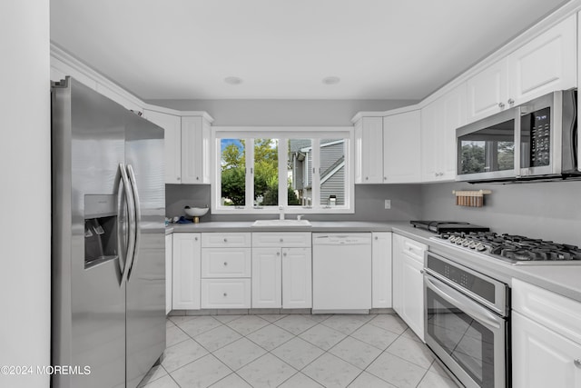 kitchen featuring appliances with stainless steel finishes, light tile patterned floors, sink, and white cabinetry