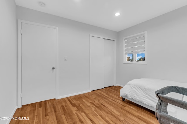 bedroom with light hardwood / wood-style flooring and a closet