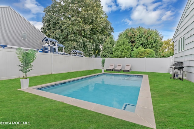 view of pool featuring a grill and a lawn