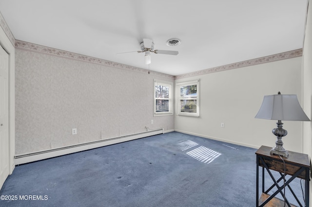 spare room featuring visible vents, baseboards, a ceiling fan, baseboard heating, and dark colored carpet