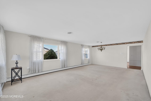 spare room with visible vents, a baseboard heating unit, a notable chandelier, and light colored carpet