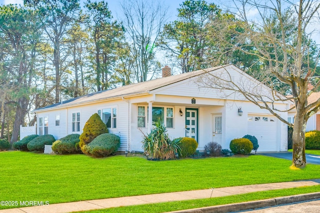 view of front of house featuring a garage, a front yard, a chimney, and aphalt driveway