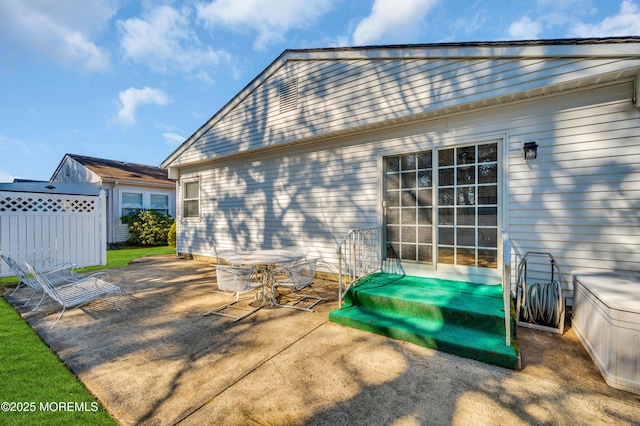 view of patio / terrace featuring entry steps, fence, and outdoor dining area