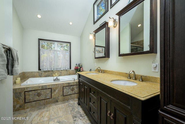 bathroom featuring a bath, double vanity, a sink, and lofted ceiling