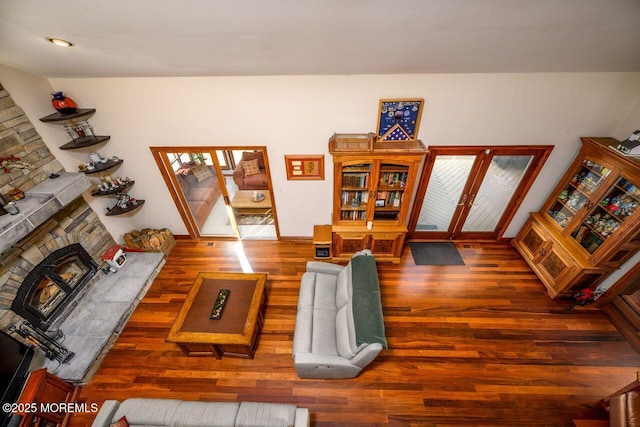 living room with a tiled fireplace, wood finished floors, and french doors