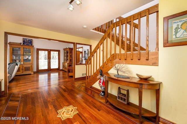 entryway featuring stairs, french doors, wood finished floors, and baseboards