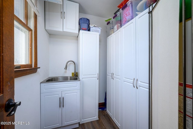 kitchen with dark wood-type flooring, white cabinetry, and a sink