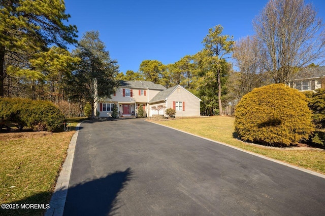 view of front facade featuring driveway and a front lawn