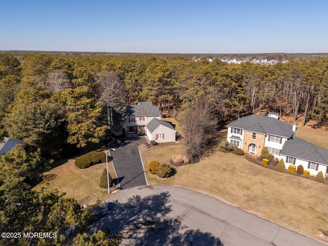 birds eye view of property featuring a forest view