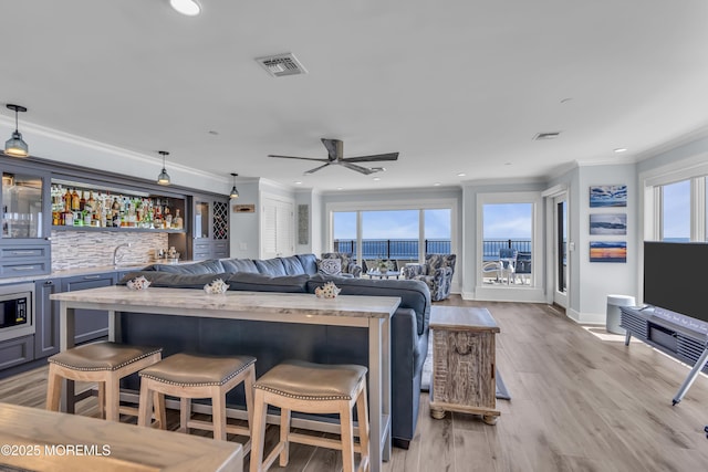 388 Ocean Ave N Unit 6D, Long Branch, NJ 07740 - living room featuring wet bar, ornamental molding, a ceiling fan, recessed lighting, and light wood-type flooring
